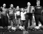 Skupina uporabnikov VDC-ja na odru med petjem in igranjem harmonike